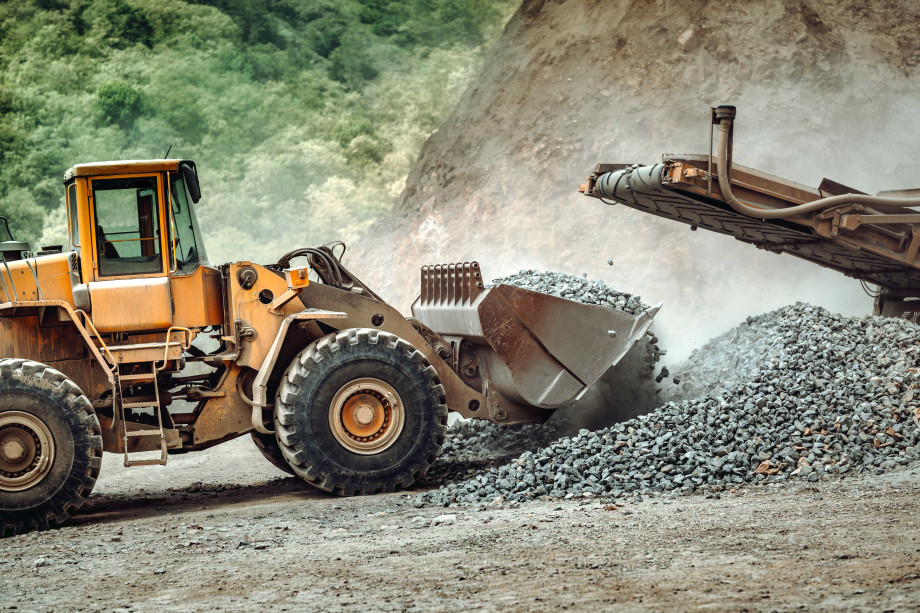 A front-end loader collects material from a crusher.